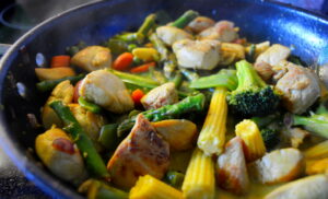 Gemüsepfanne mit gelben Maiskolben aus dem Wok